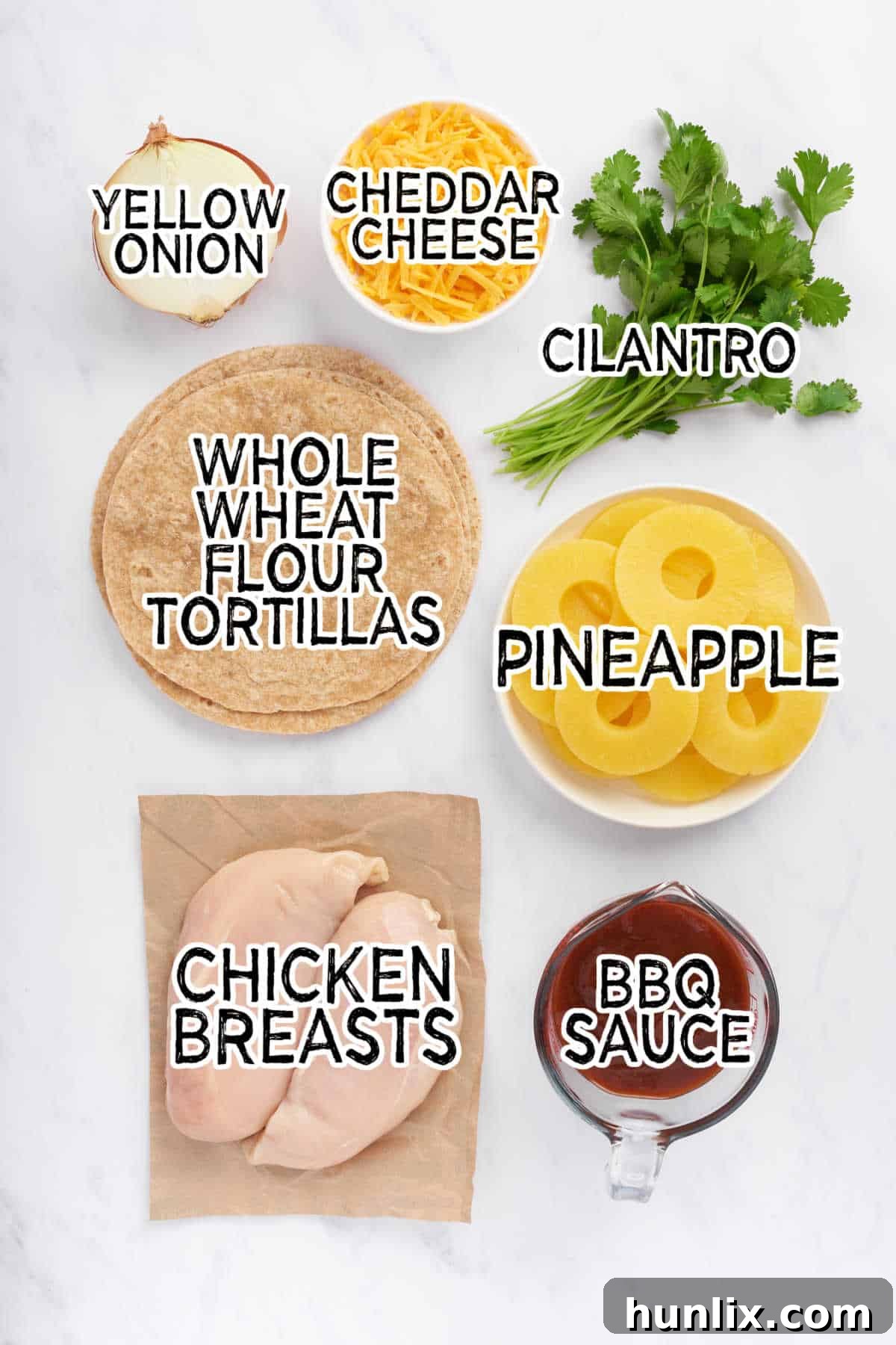 A vibrant selection of ingredients including chicken breasts, barbecue sauce, pineapple slices, onions, tortillas, and shredded cheese, ready to be prepared for BBQ Chicken and Pineapple Quesadillas.
