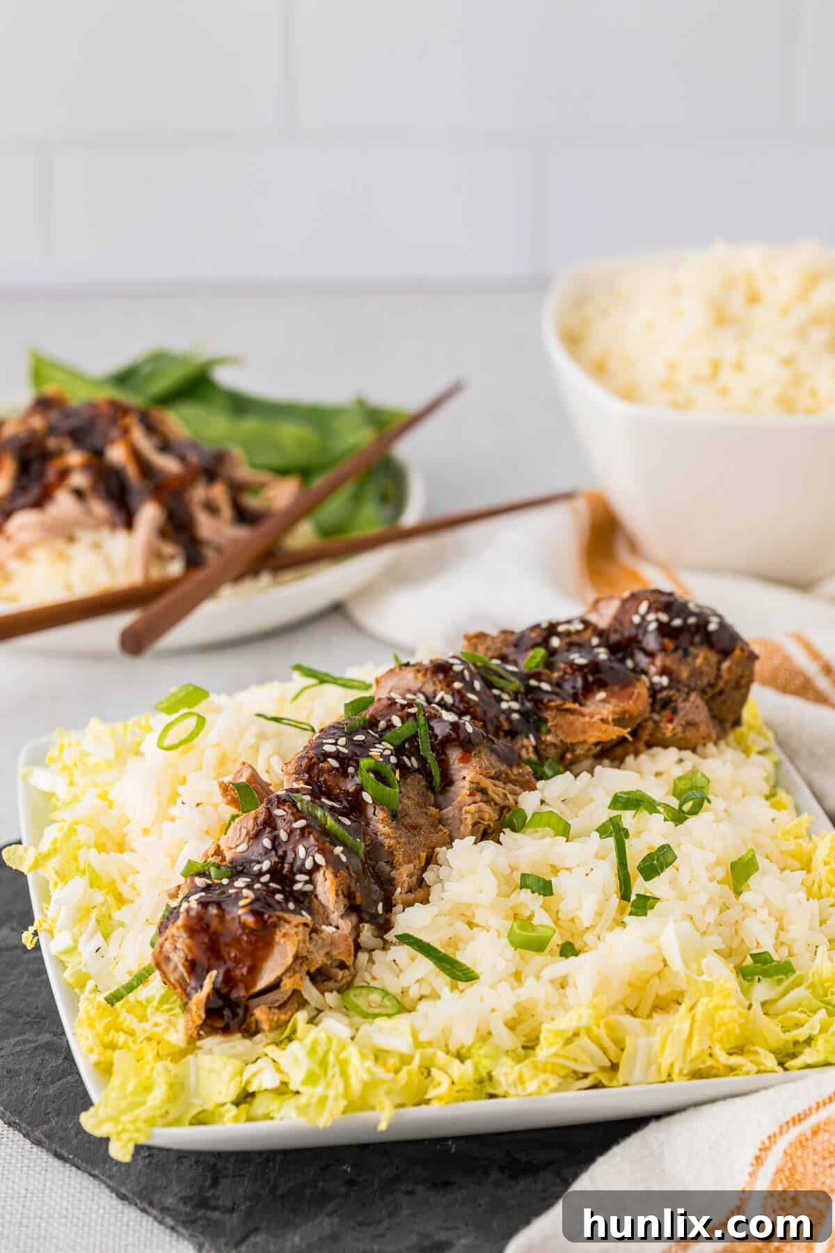 Soy Ginger Pork Tenderloin 2 Sliced Asian pork tenderloin served on a bed of rice and steamed cabbage.