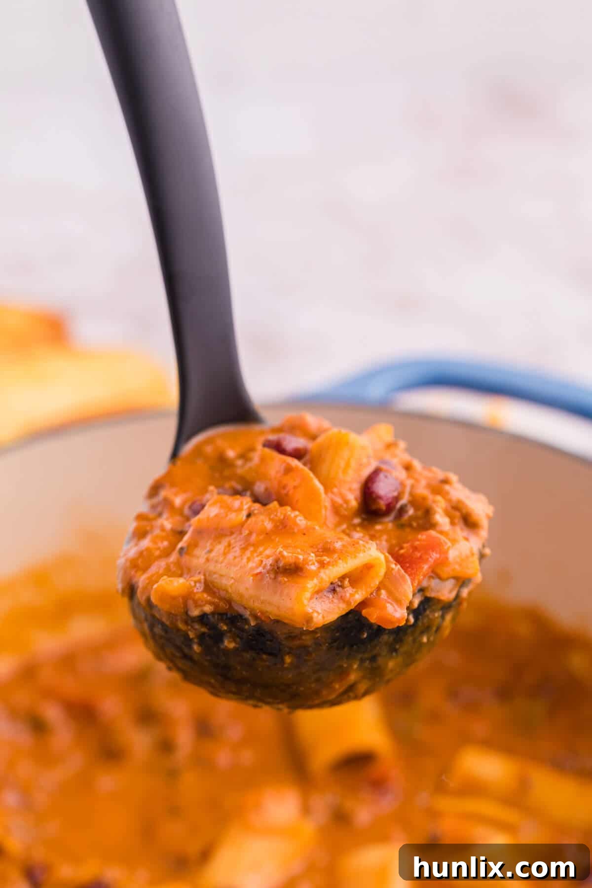 Chili rigatoni in a ladle.