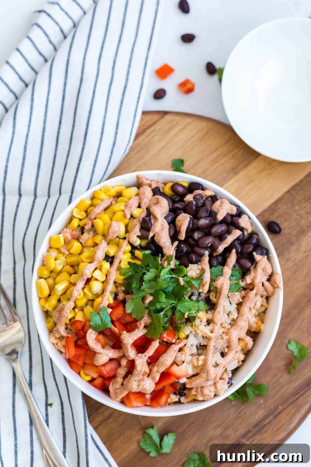Cauliflower rice enchilada bowl with all the fixings, topped with fresh avocado.