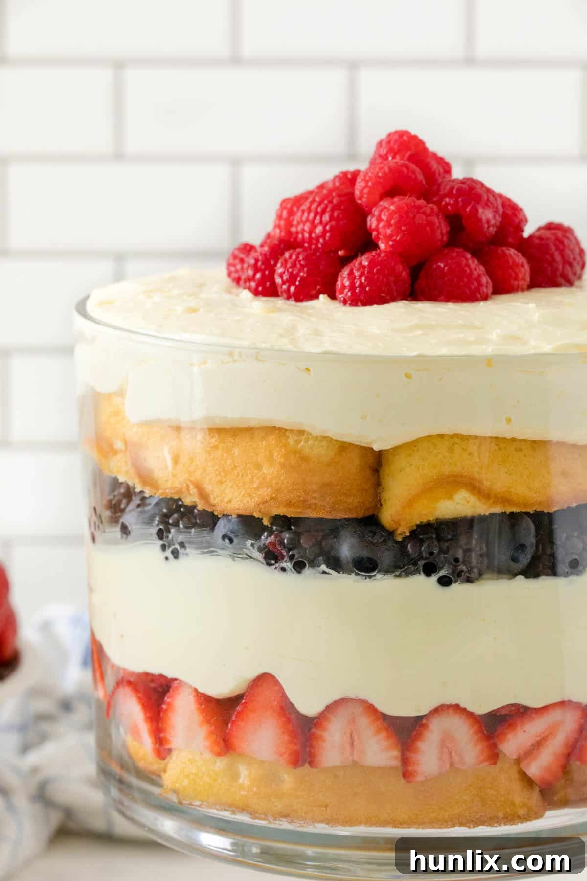 A close-up side view of the Berry Cheesecake Trifle, showing distinct layers of Twinkies, cheesecake filling, and berries.