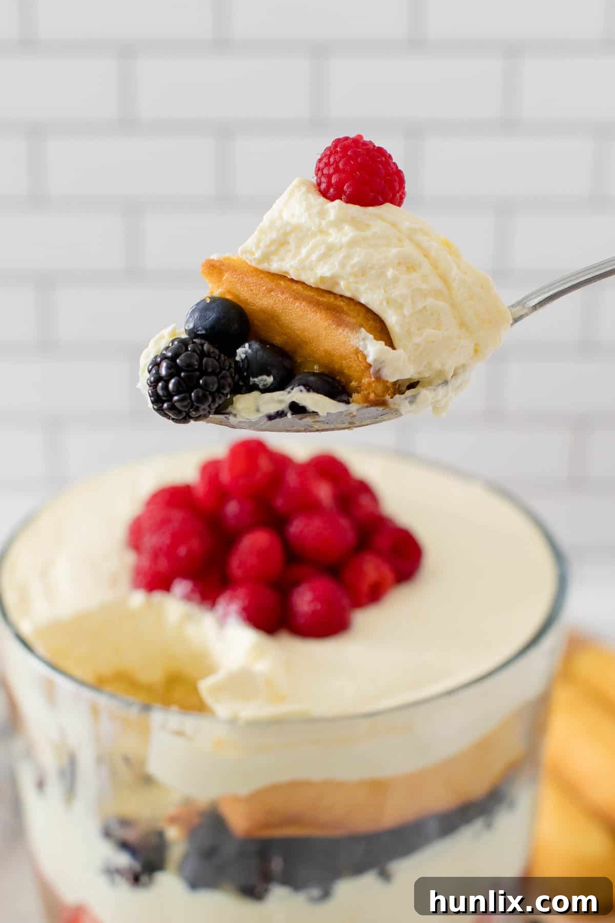 A serving of Berry Cheesecake Trifle on a plate, showing the individual layers clearly.