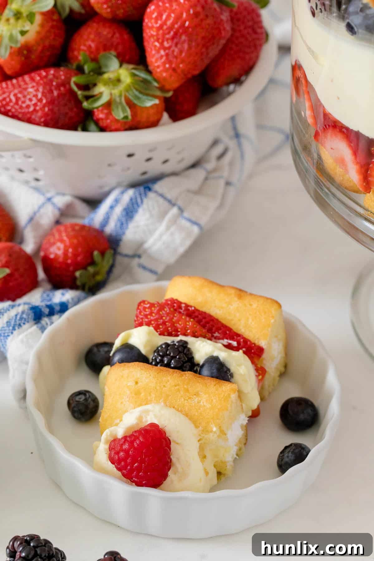A beautiful close-up of the Berry Cheesecake Trifle served on a plate, highlighting the creamy textures and fresh fruit.