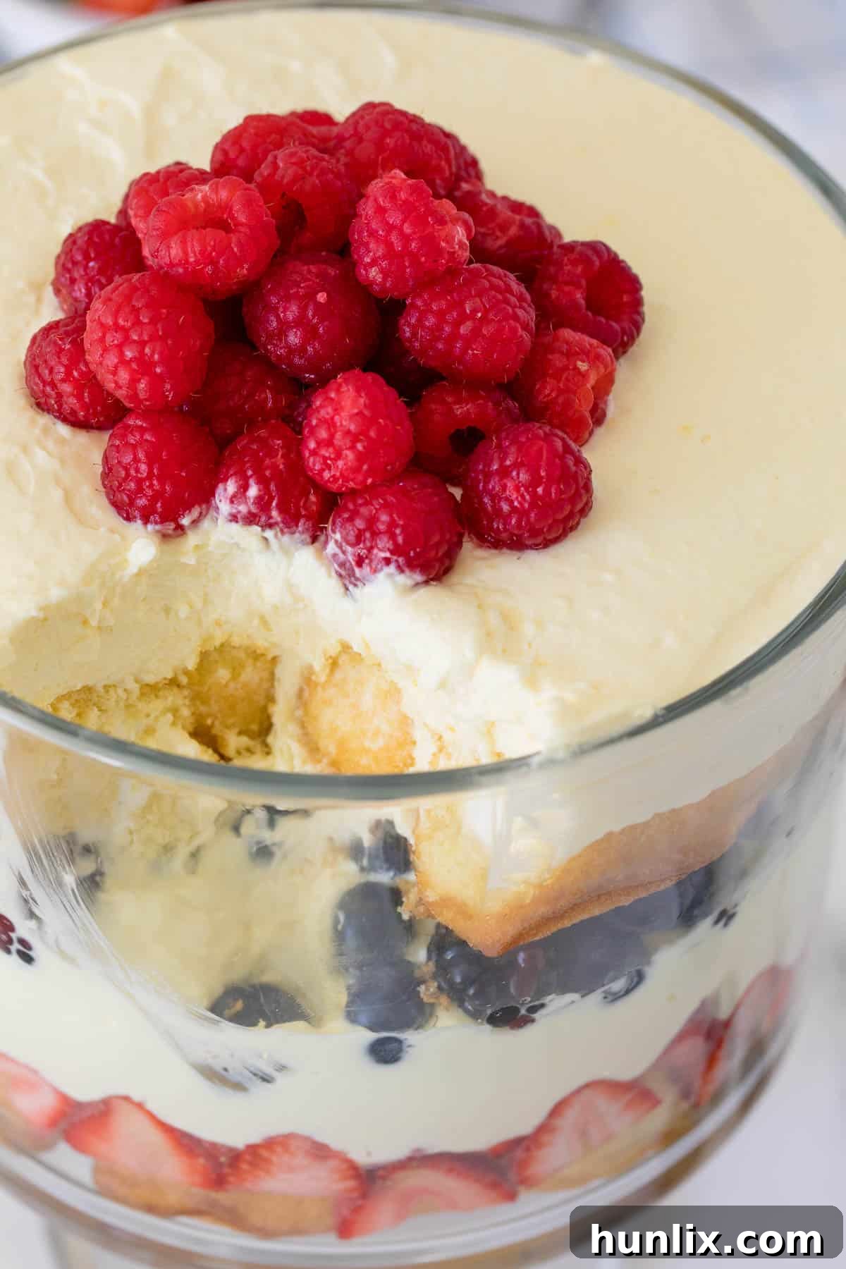 The Berry Cheesecake Trifle with a scoop removed, showing the luscious layers and inviting texture.