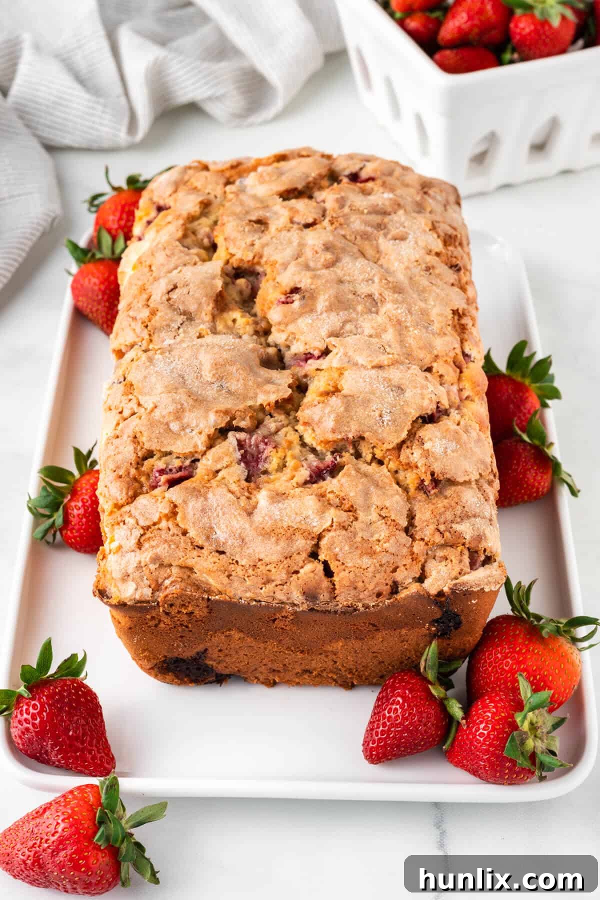 Strawberry Cheesecake Bread 2 A beautifully sliced Cream Cheese Stuffed Strawberry Bread on a platter, showcasing the creamy filling and fresh strawberry pieces.