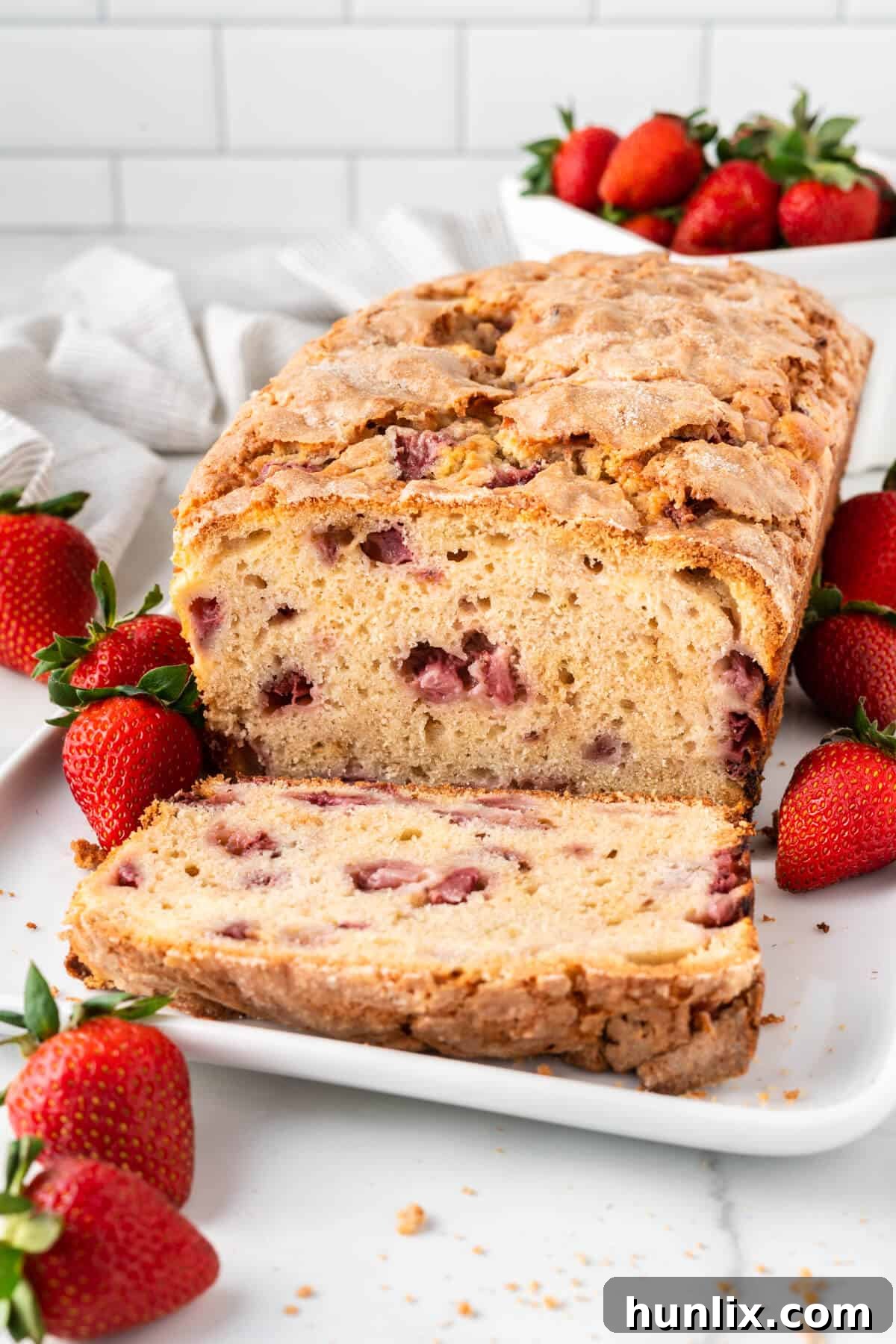 Strawberry Cheesecake Bread 12 Several slices of cream cheese stuffed strawberry bread arranged beautifully on a white platter, ready to be served.