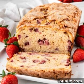 Strawberry bread with slices cut off on a platter.