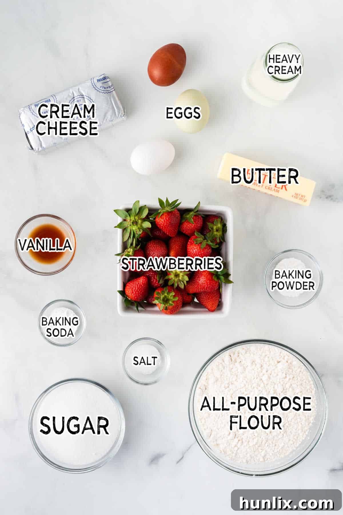 Strawberry Cheesecake Bread 3 Various ingredients for strawberry bread laid out on a kitchen counter, including fresh strawberries, flour, sugar, and cream cheese.