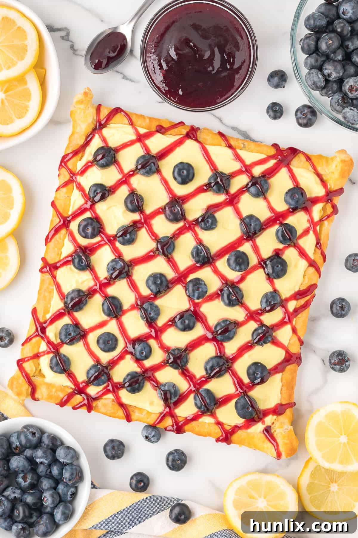 Blueberry lemon tart surrounded by fresh blueberries and lemons, showcasing its rustic beauty.