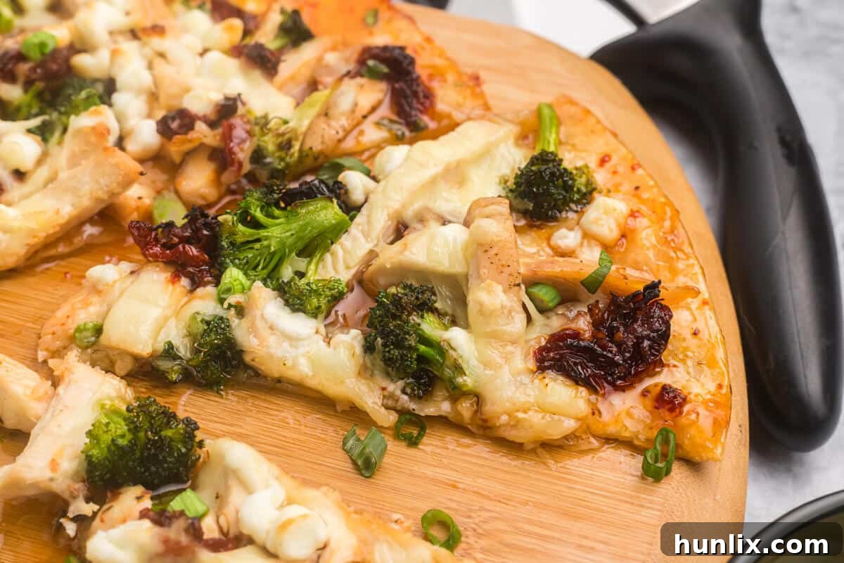 Slices of sweet chili chicken thai pizza on a wooden cutting board.