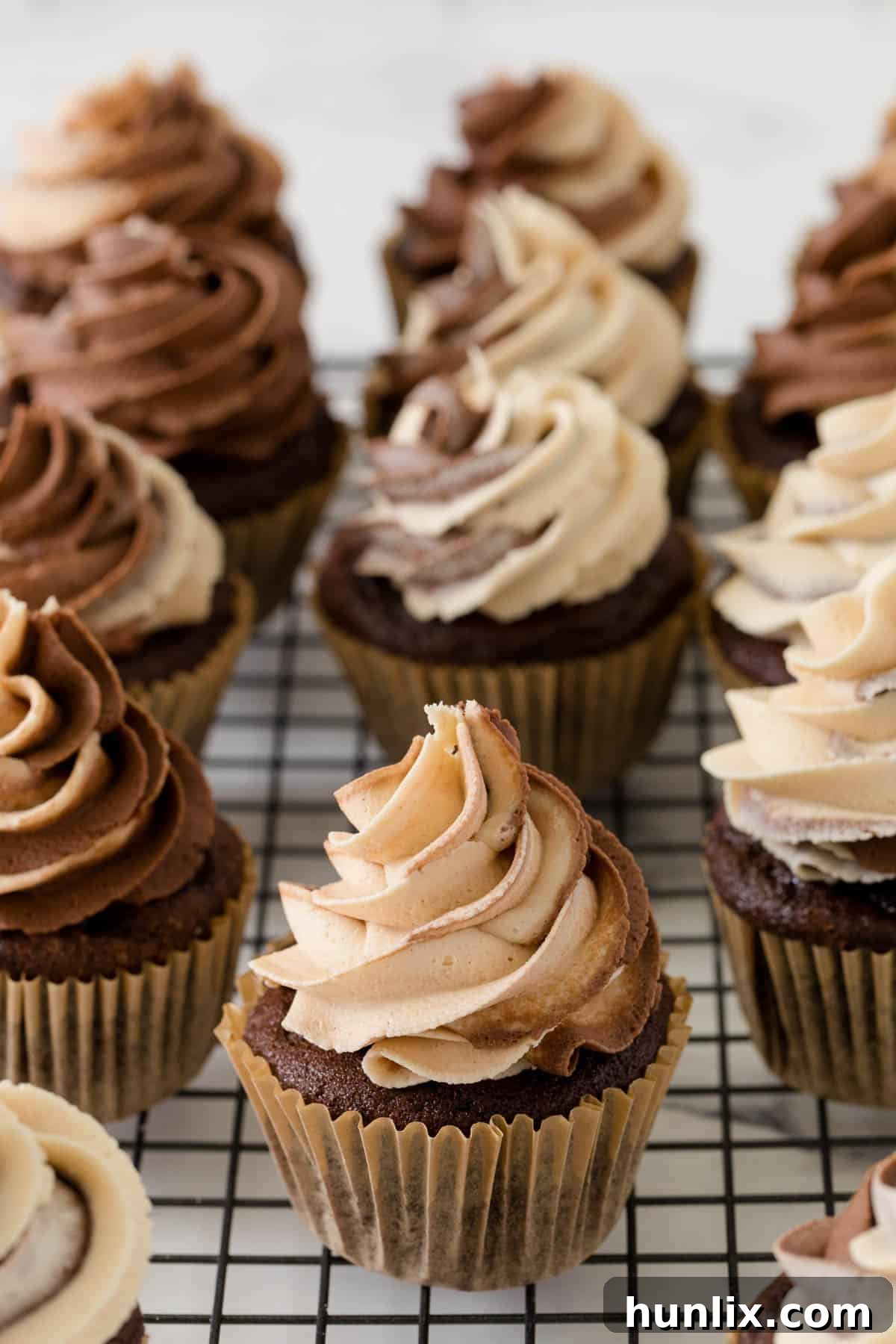 Decadent Chocolate Peanut Butter Cupcakes arranged on a wire cooling rack, showcasing their delightful swirled frosting and deep chocolate color.