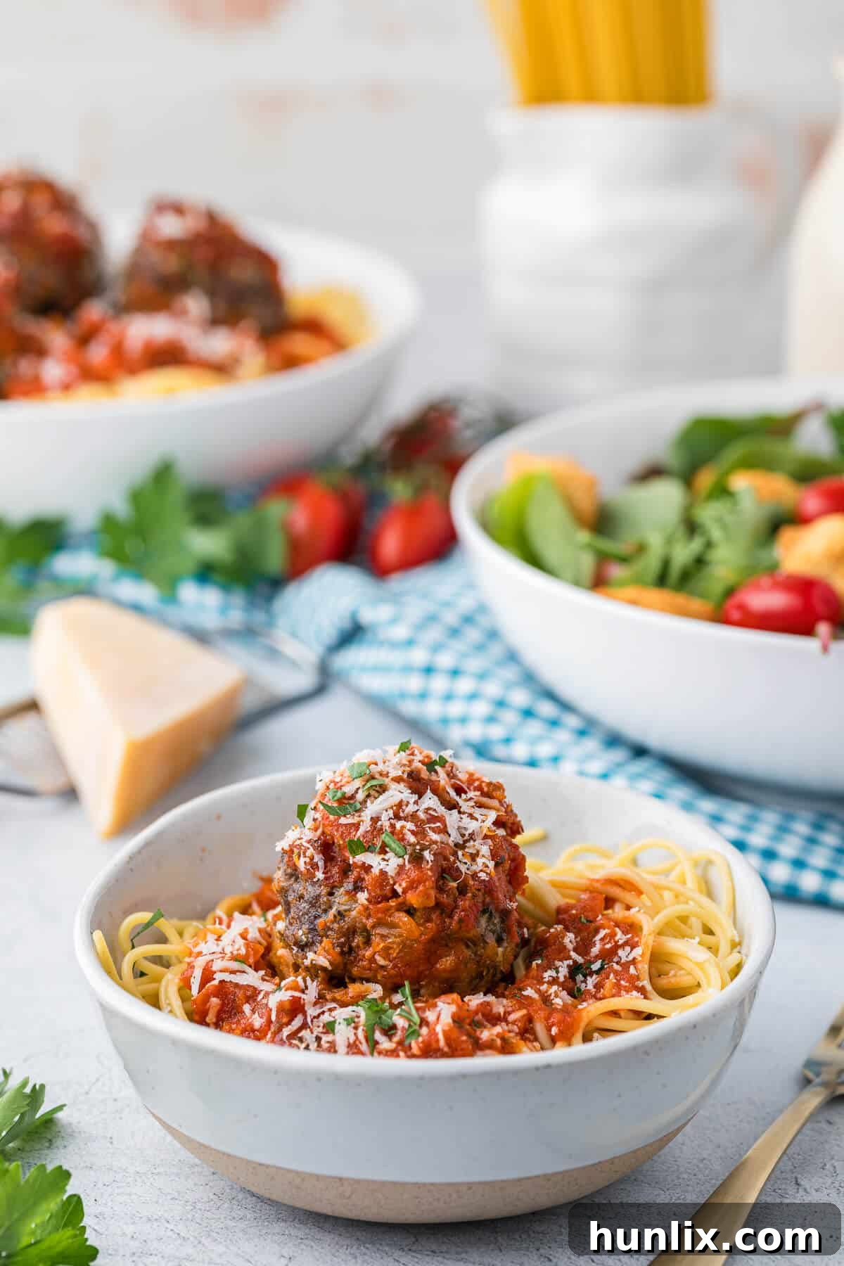 A cozy bowl filled with cheesy meatballs and spaghetti, ready for a comforting meal.
