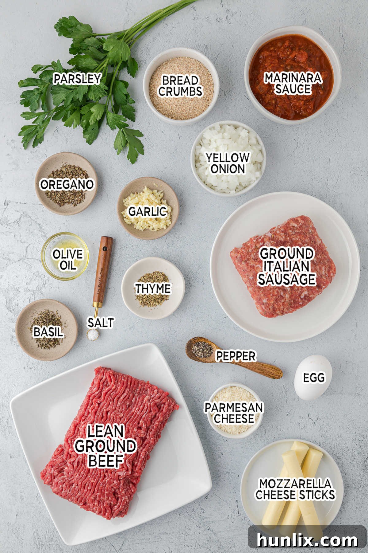 A curated selection of fresh ingredients laid out for making cheesy meatballs.