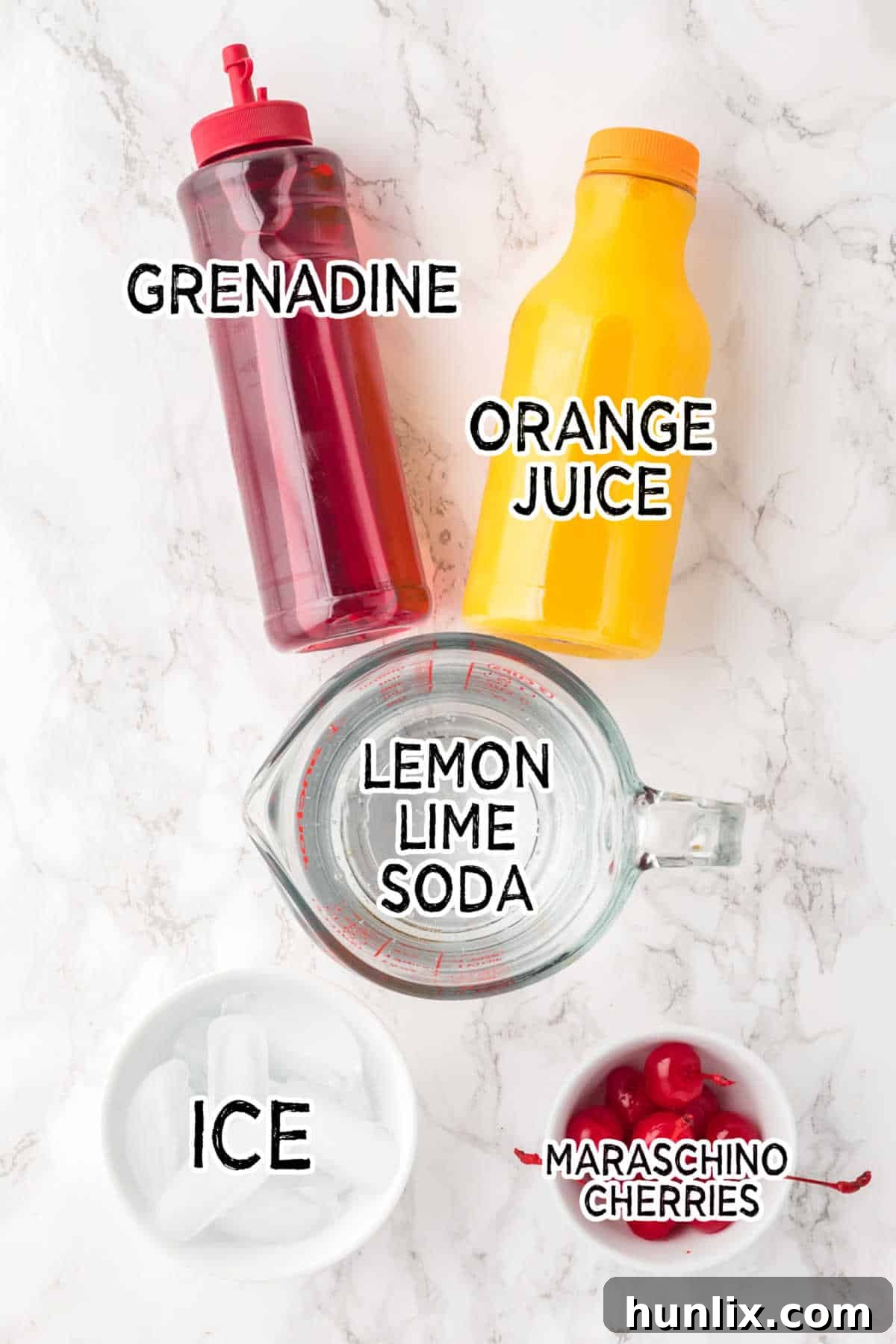 Ingredients on a white marble counter, including orange juice, lemon-lime soda, grenadine, and maraschino cherries.