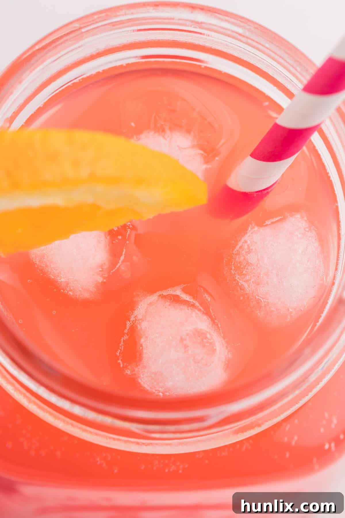 Overhead view of the Shirley Temple recipe in a glass with a straw and garnishes.