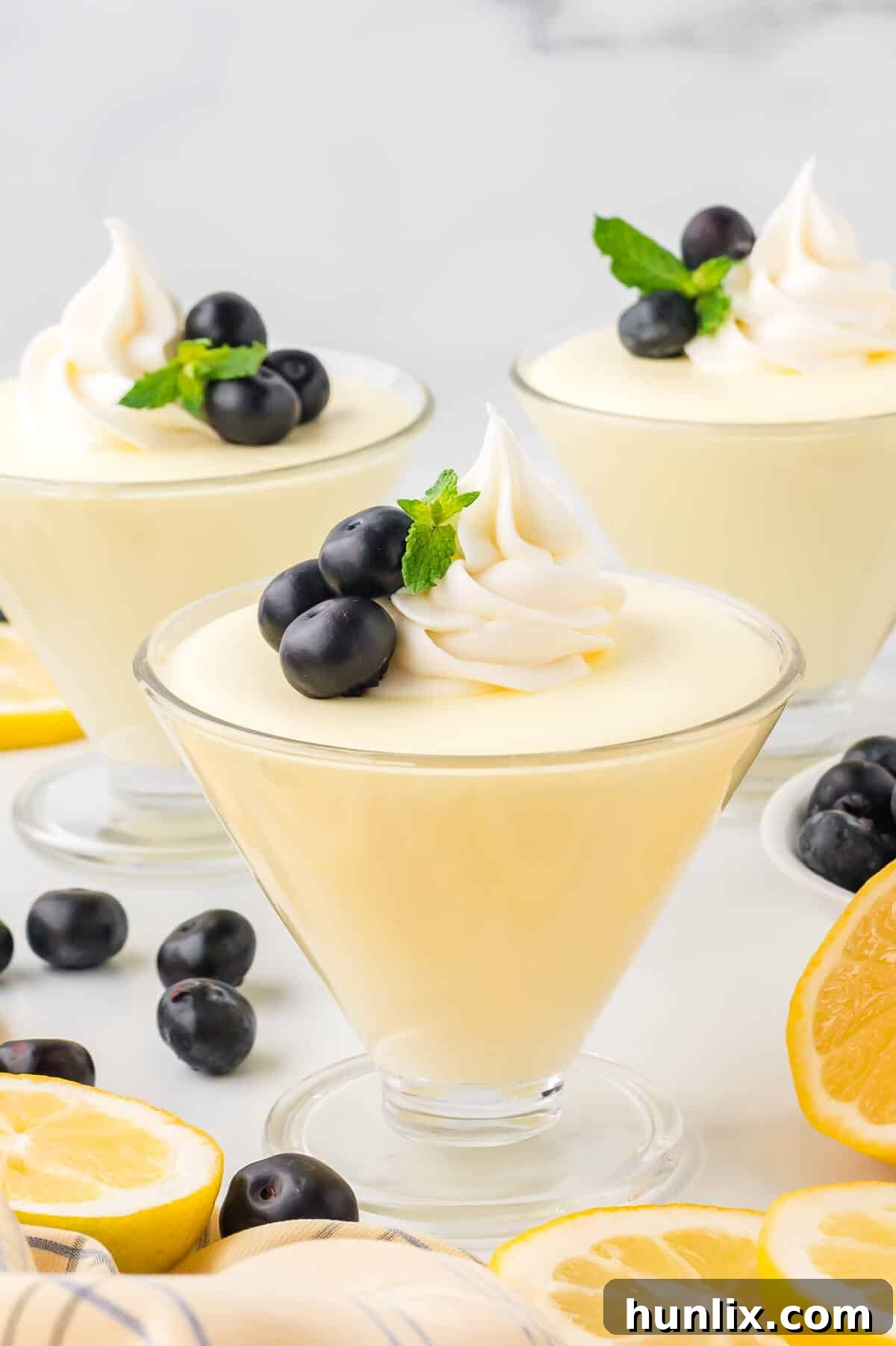 Lemon cheesecake mousse in a parfait dish, garnished with fresh berries.