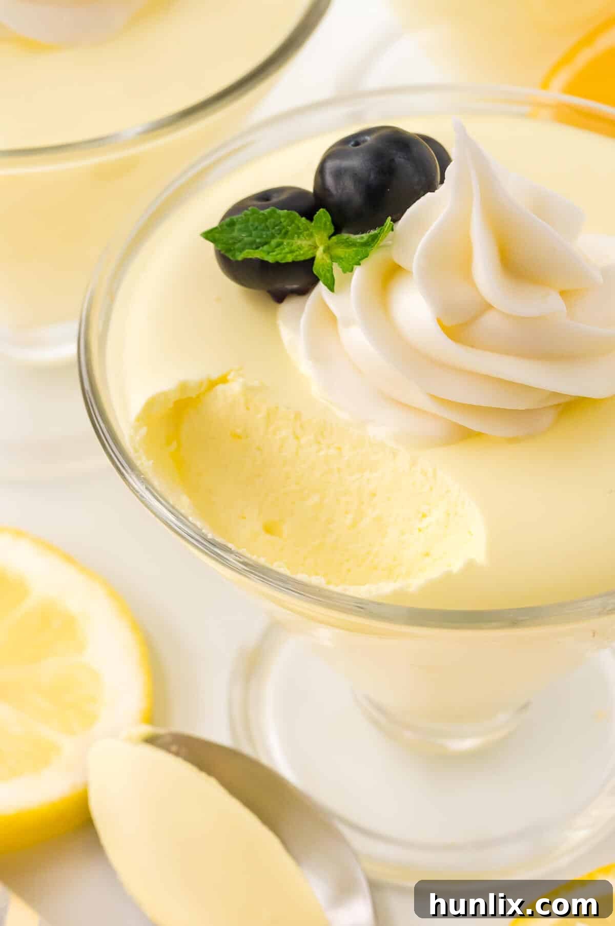 Lemon cheesecake mousse with a spoonful taken out, showcasing its fluffy texture.