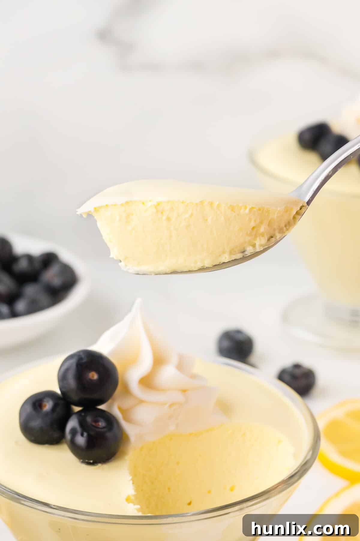 Lemon cheesecake mousse held on a spoon, ready to eat.