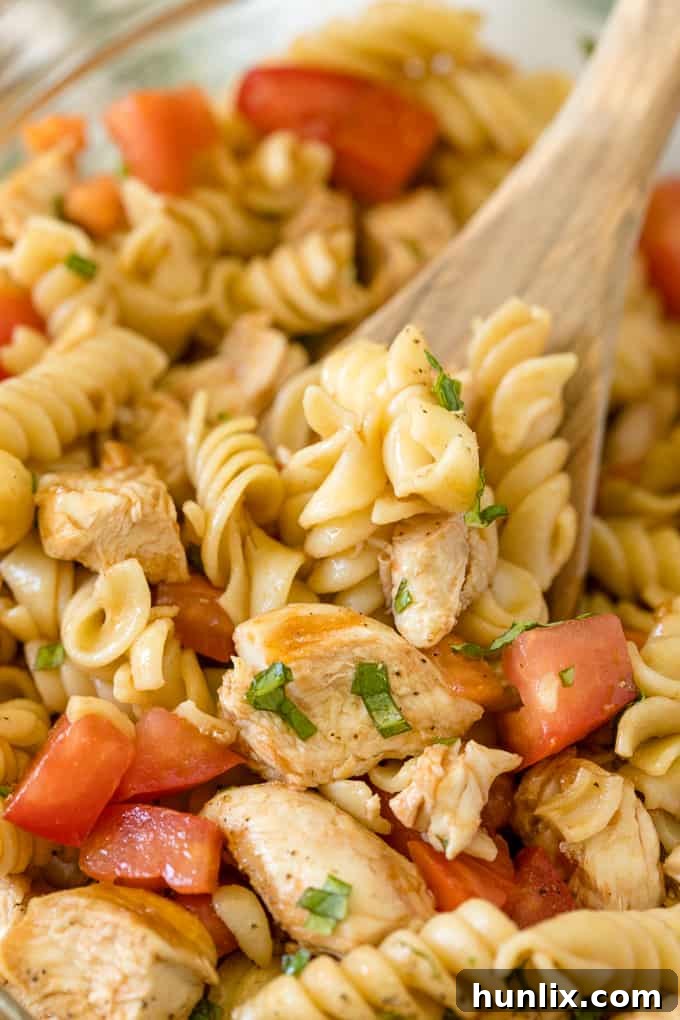 Overhead shot of Bruschetta Chicken Pasta Salad in a serving bowl, ready to be enjoyed.