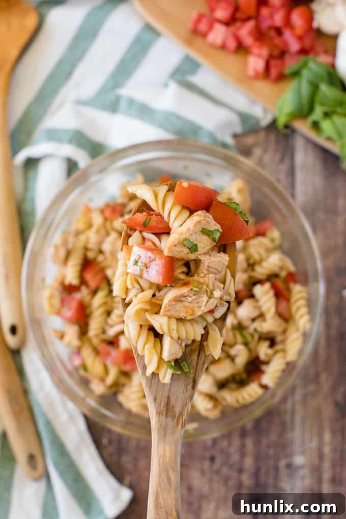 Individual serving of Bruschetta Chicken Pasta Salad in a white bowl.