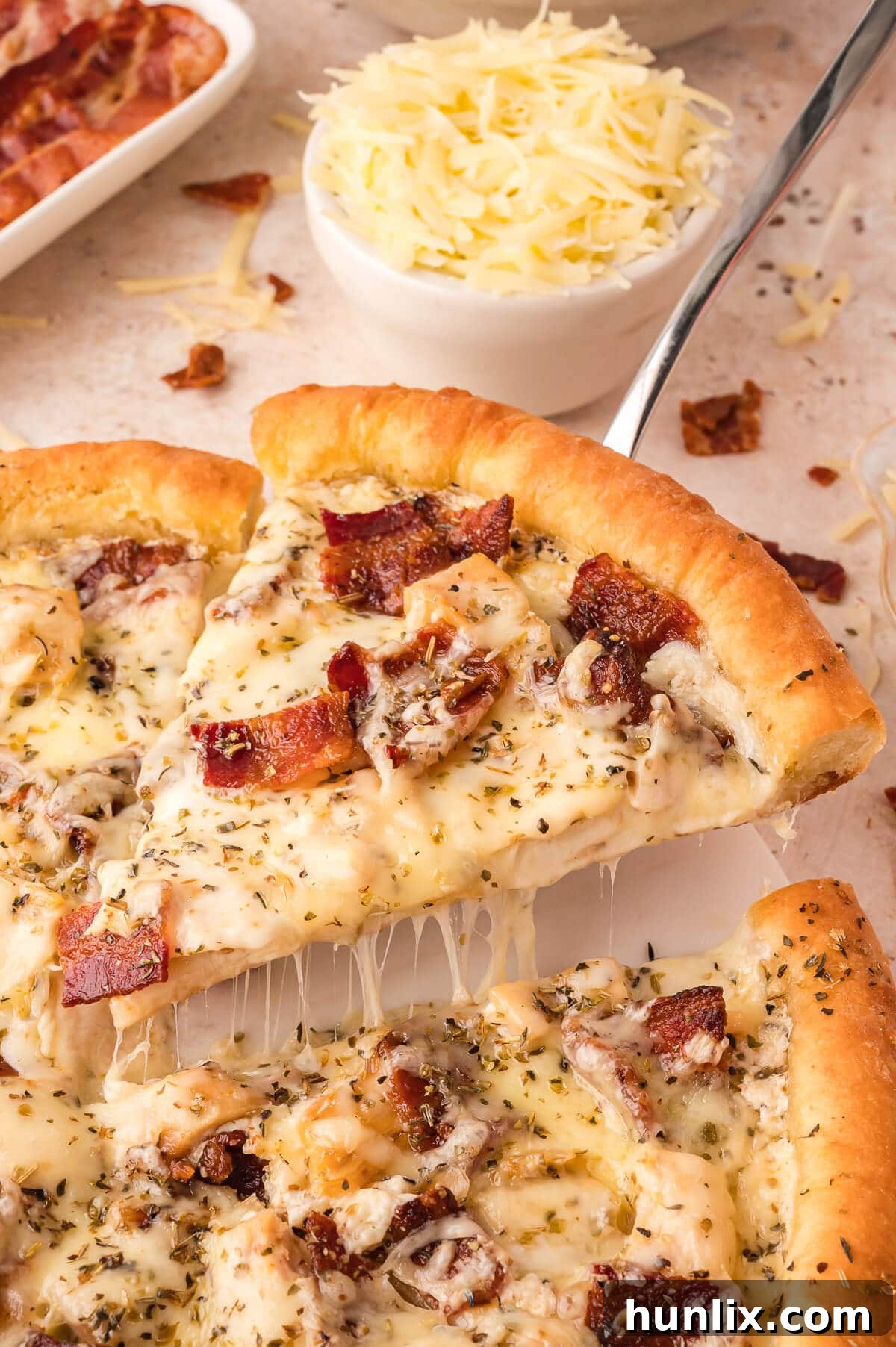 Signature Chicken Caesar Pizza 5 A perfectly cooked slice of Chicken Caesar Pizza being lifted off the pan with a spatula, showcasing its golden crust and melted cheese.