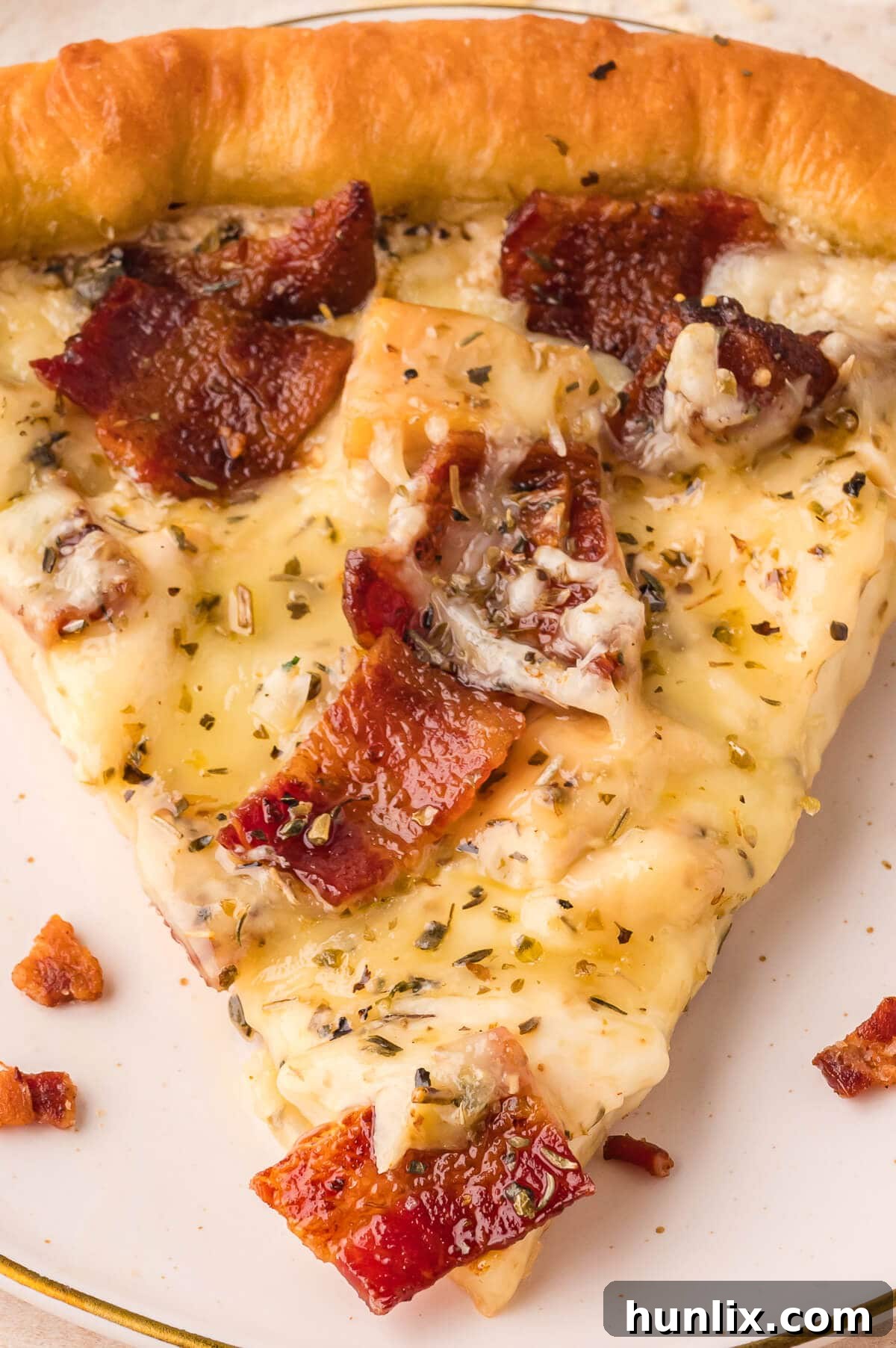 Signature Chicken Caesar Pizza 7 A close-up view of a slice of Chicken Caesar Pizza, showcasing the texture of the crust and the rich toppings.