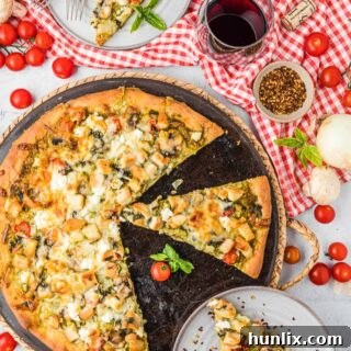 The recipe on a pizza pan with slices removed, showcasing the delicious chicken pesto pizza.