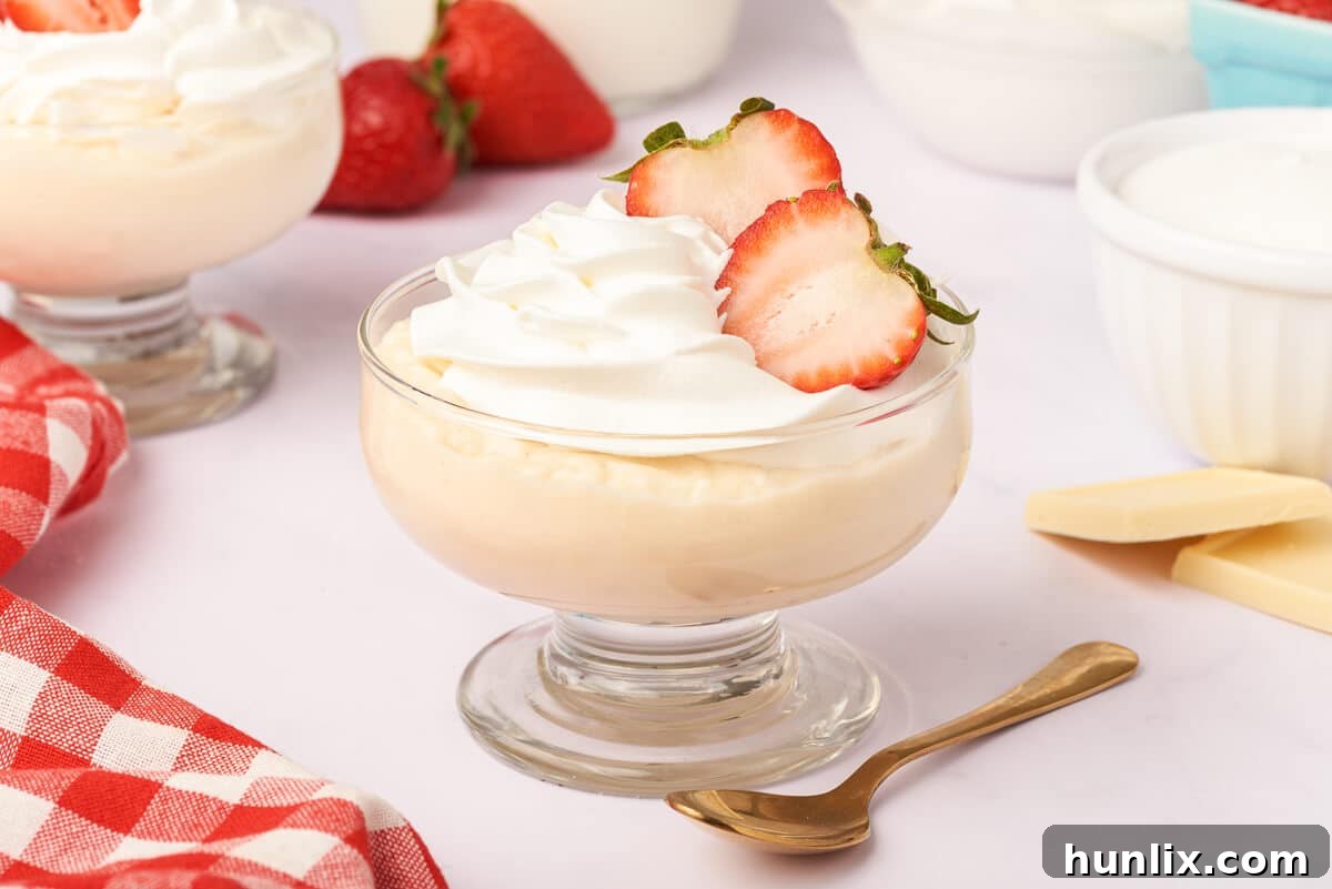 A clear glass dish showcasing layers of white chocolate pudding, ready to be adorned with toppings.