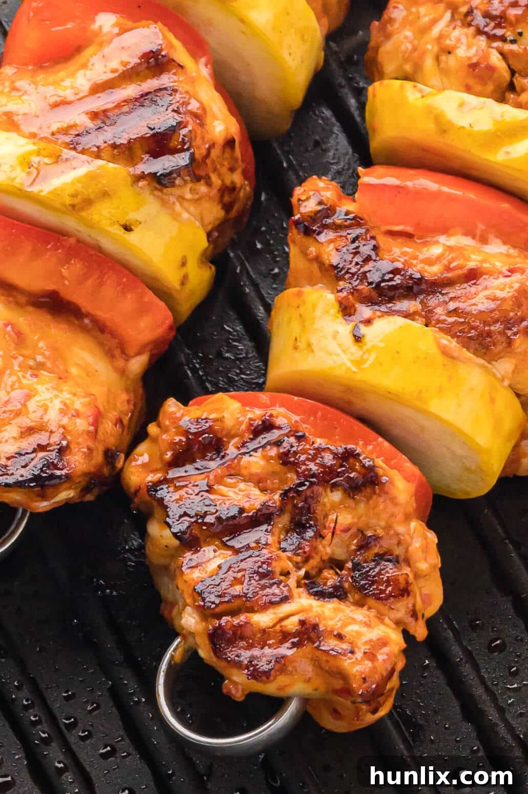 Chipotle chicken skewers on a grill, perfectly charred with vibrant vegetables.