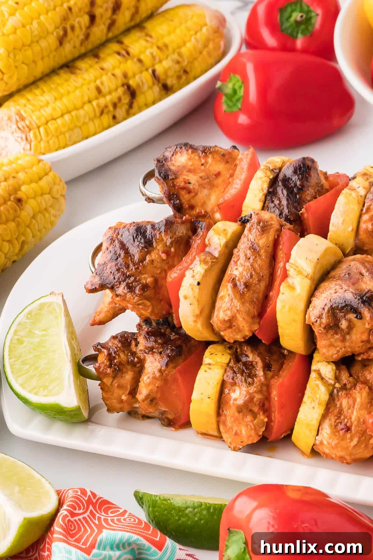 A platter of beautifully grilled chipotle chicken skewers, garnished and ready for serving.
