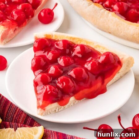 A slice of cherry cheesecake pizza on a plate.