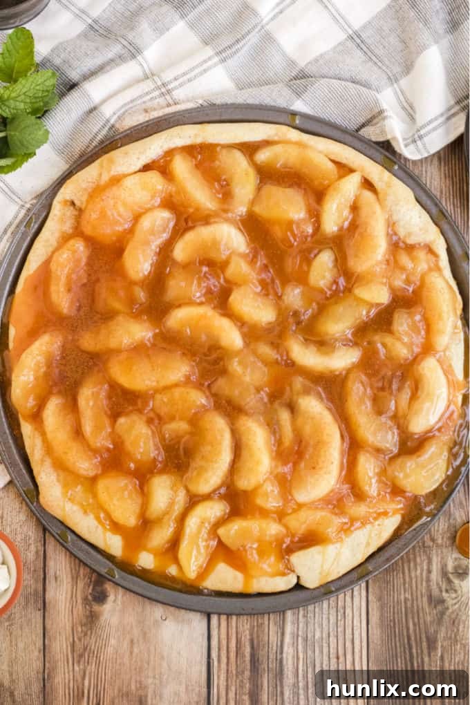 Caramel Apple Pizza - The PERFECT fall dessert pizza! Sweet cinnamon apple pie filling with rich caramel covering a basic pizza crust for the taste of pie without the mess and wait.