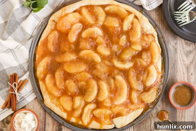 Caramel Apple Pizza - The PERFECT fall dessert pizza! Sweet cinnamon apple pie filling with rich caramel covering a basic pizza crust for the taste of pie without the mess and wait.