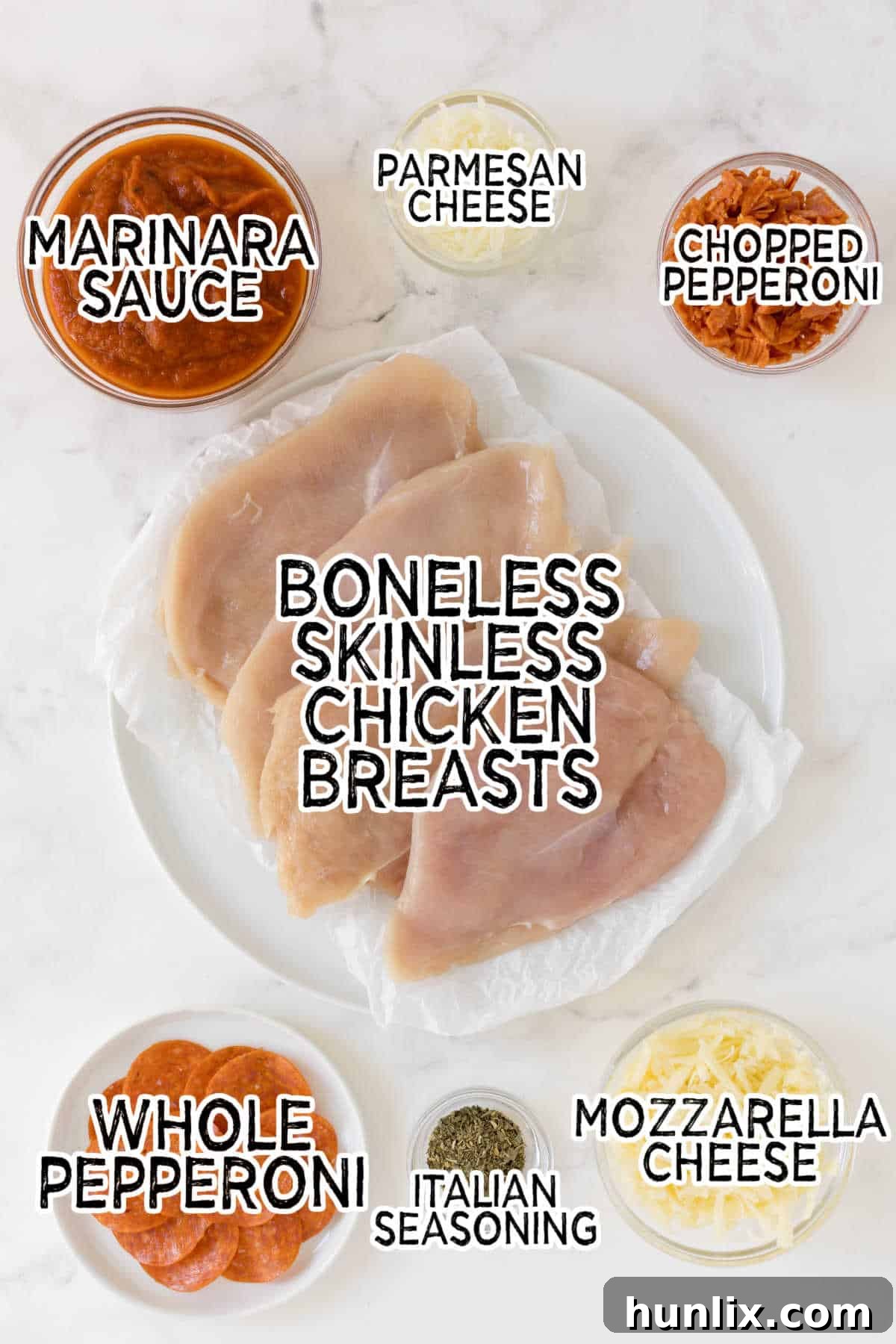 All the fresh ingredients laid out to make pizza stuffed chicken: chicken breasts, marinara, spices, and cheeses.