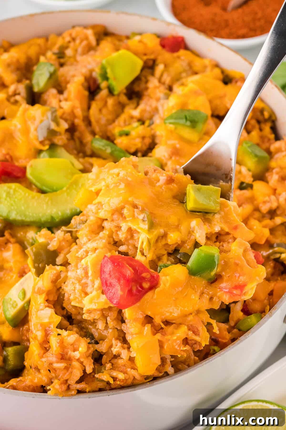 Chicken fajita rice in a pan with a serving spoon, ready to be dished out.