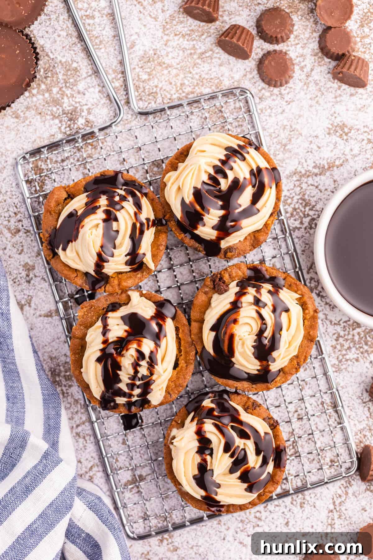 Delicious Reese's Peanut Butter Cookie Cups 2 Irresistible Reese's Peanut Butter Cookie Cups arranged neatly on a wire cooling rack, showcasing their golden-brown edges and luscious frosting.