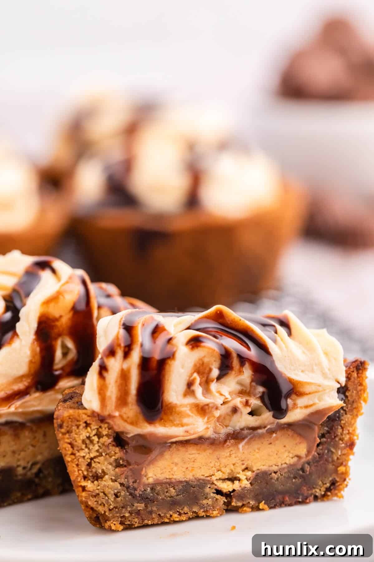 Delicious Reese's Peanut Butter Cookie Cups 5 Two Reese's Peanut Butter Cookie Cups cut in half, revealing the soft cookie base, the melted Reese's center, and the creamy peanut butter frosting.