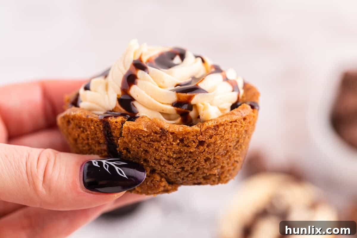 Delicious Reese's Peanut Butter Cookie Cups 6 A hand reaching for a Reese's Peanut Butter Cookie Cup, highlighting the deliciousness and inviting nature of the dessert.