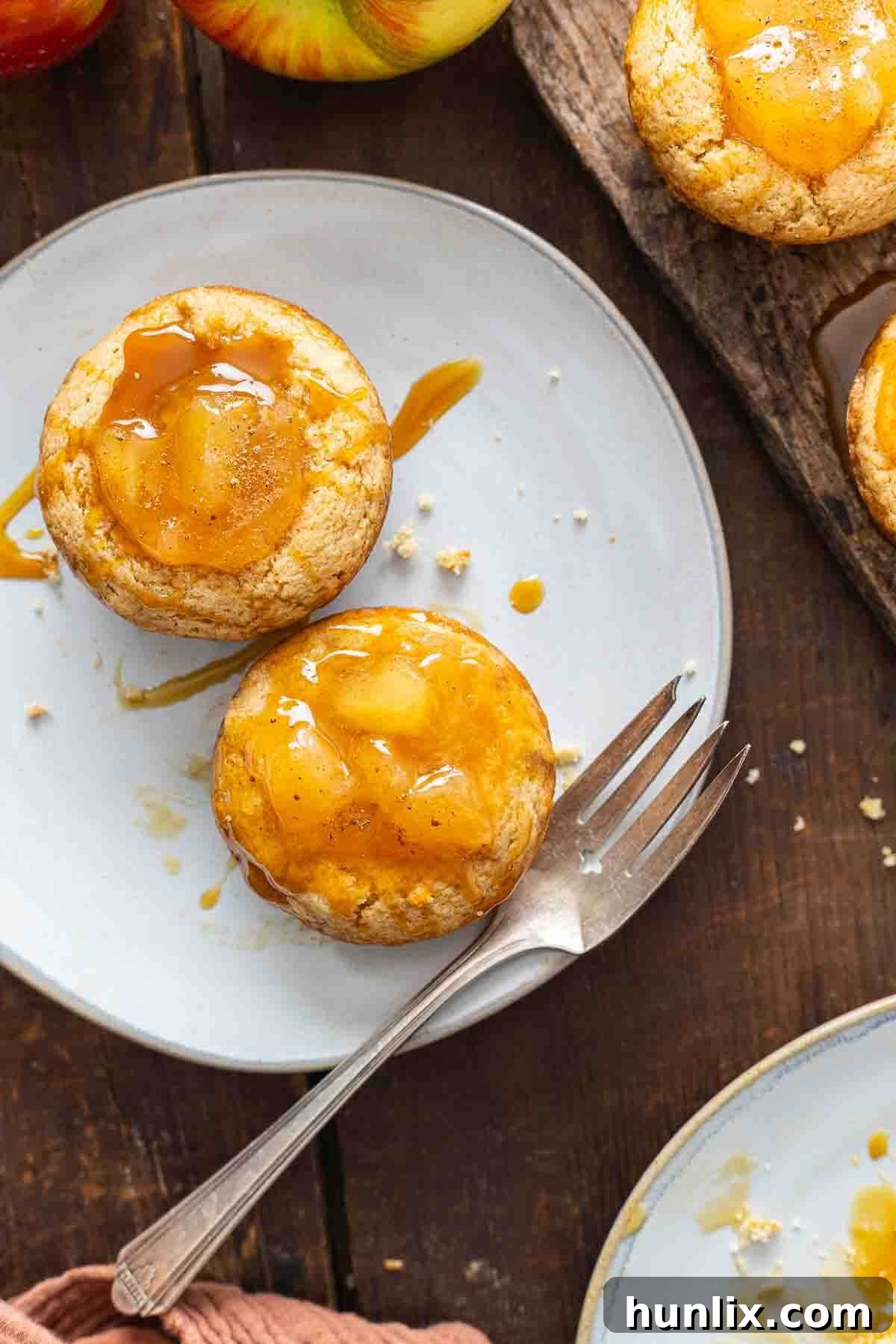 Two Caramel Apple Cake Cups served on a small plate with a fork, ready to be enjoyed.