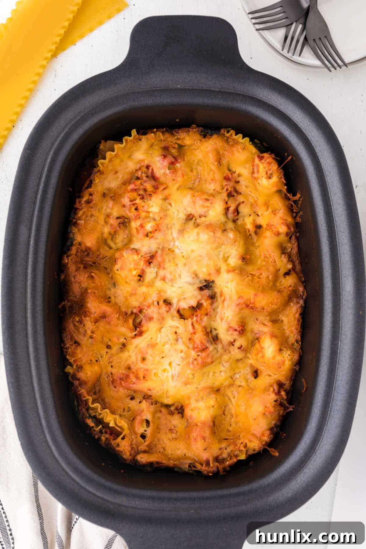 Cooked lasagna in a slow cooker, showcasing its rich, layered texture and melted cheese.
