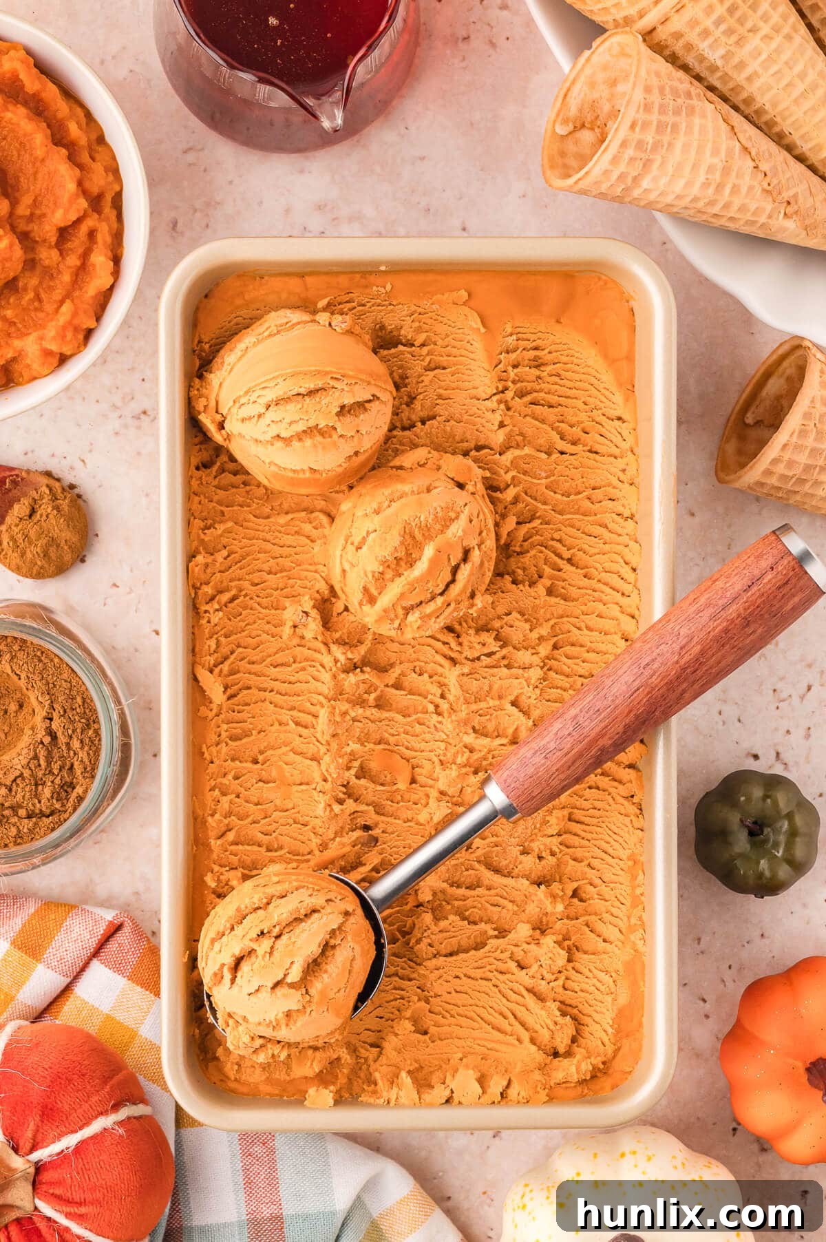 Creamy pumpkin pie ice cream in a glass container, ready to be served.