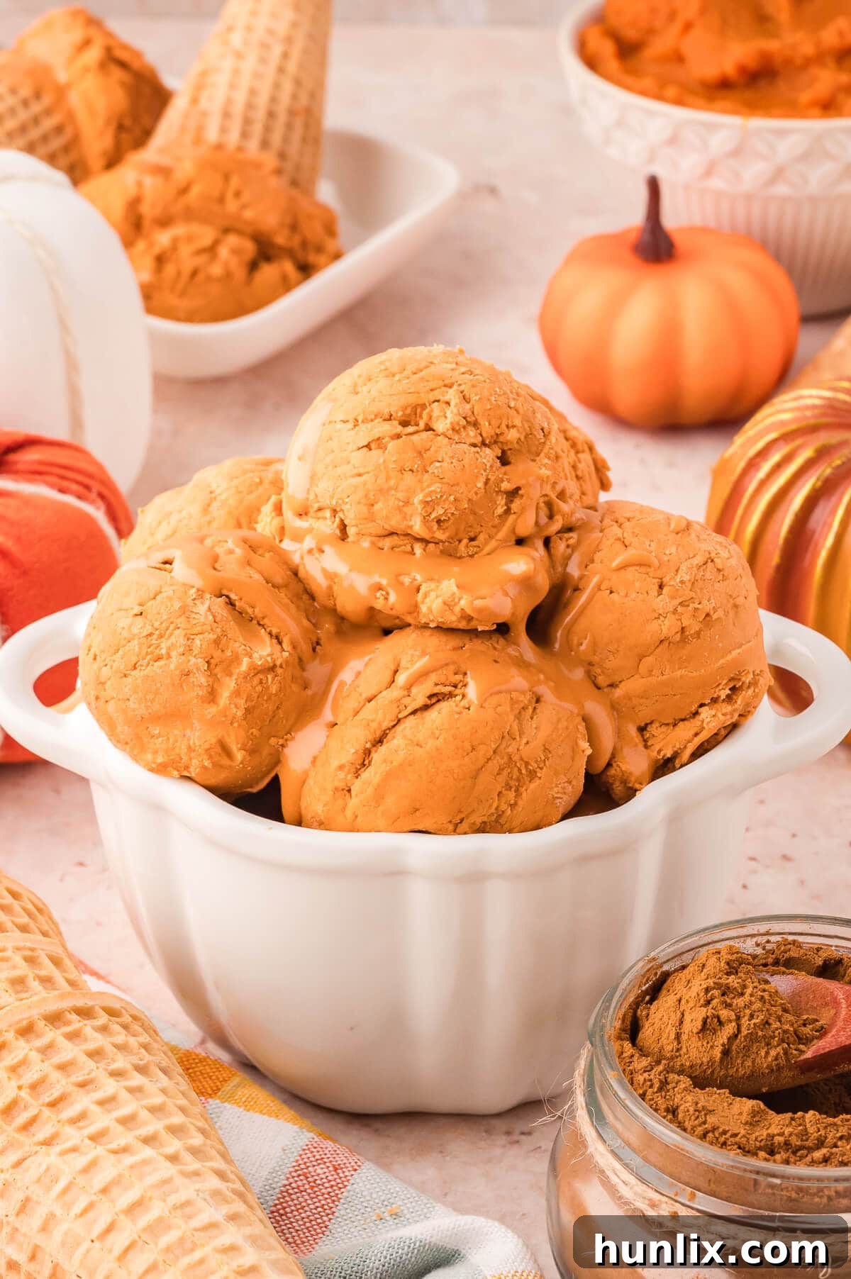A beautiful bowl of pumpkin pie ice cream, topped with a swirl of cream.