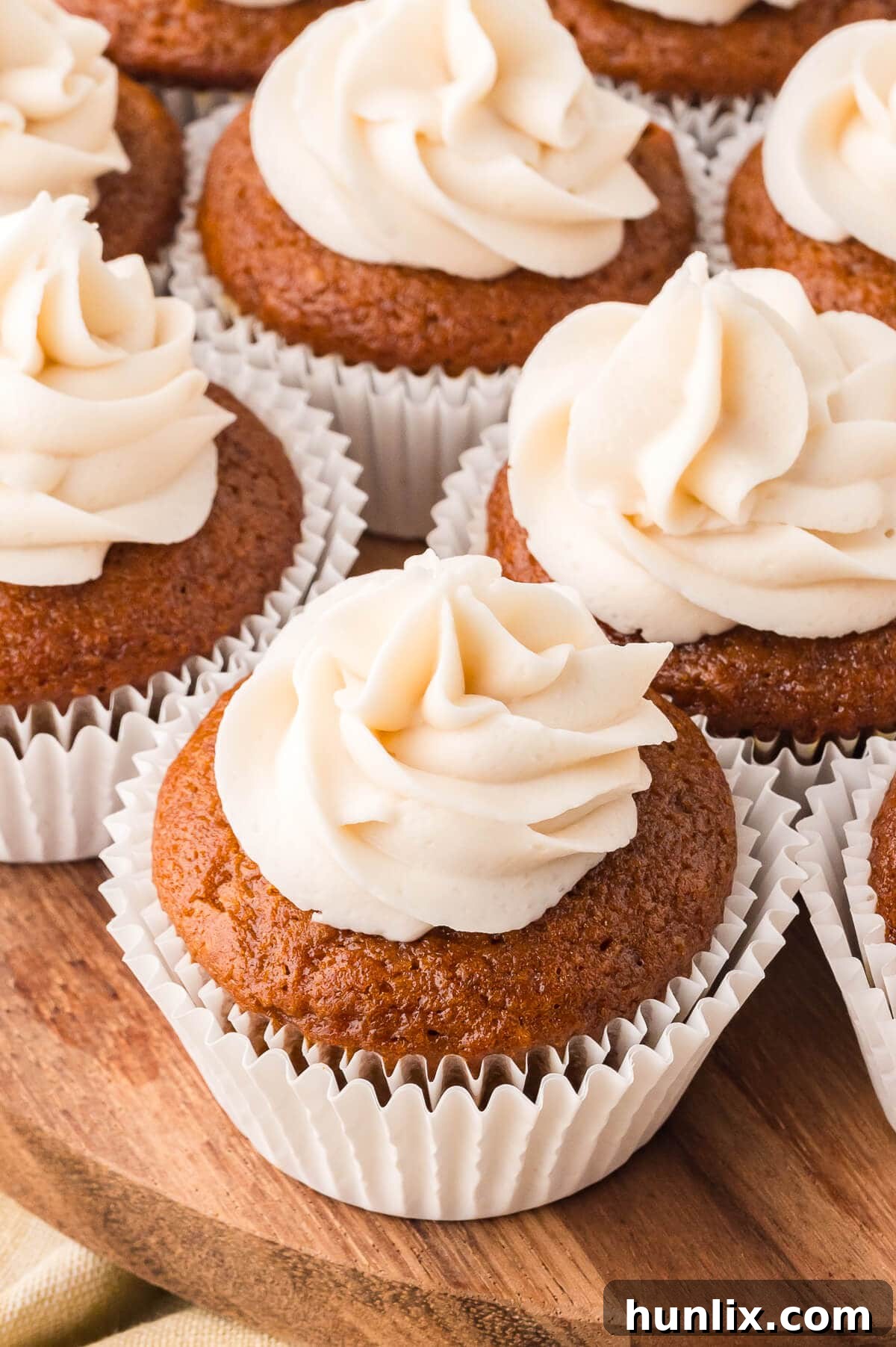 Pumpkin Spice Latte Cupcakes on a wooden surface.