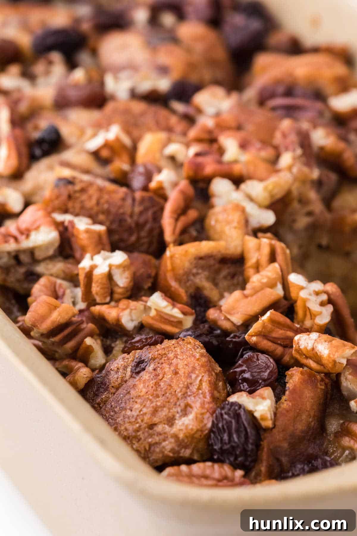 A golden-brown slow cooker cinnamon raisin bread pudding in a loaf pan, perfectly baked and ready to be sliced, showcasing its inviting texture.