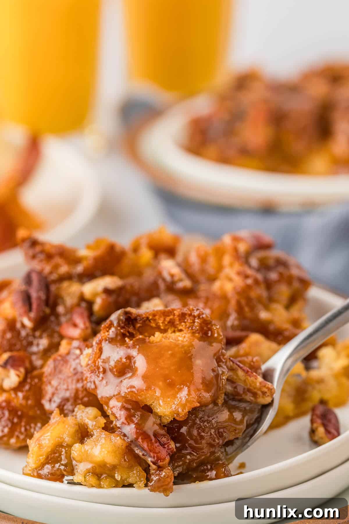 A delectable piece of Caramel Pecan Breakfast Casserole delicately lifted on a fork, showing its soft texture and rich topping.