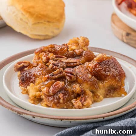 A slice of the recipe on a plate, highlighting the delicious layers of caramel, pecans, and soft donut.