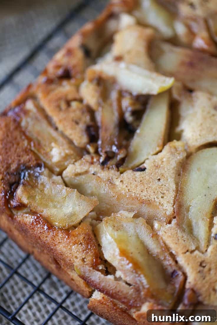 Caramelized Apple Inverted Delight 12 Freshly baked Apple Upside Down Cake cooling on a rack, revealing its perfectly caramelized apple topping after being carefully inverted from the pan.