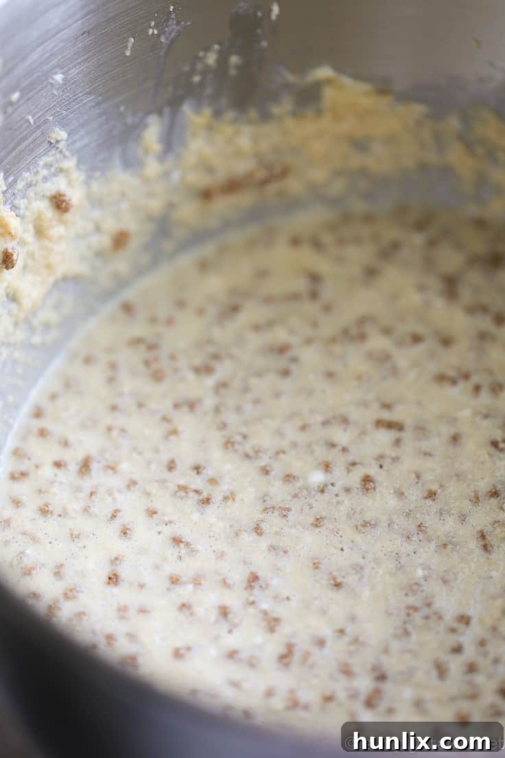 Caramelized Apple Inverted Delight 8 Apple Upside Down Cake batter preparation – All-Bran Buds being mixed into the cake batter, ensuring a consistent distribution of fiber throughout the dessert.