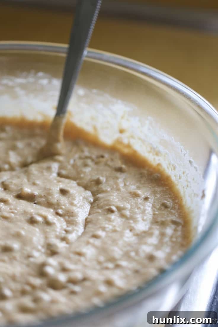 Caramelized Apple Inverted Delight 10 Wet ingredients for Apple Upside Down Cake being combined, including softened butter, brown sugar, eggs, milk, All-Bran Buds, caramel extract, and sour cream.