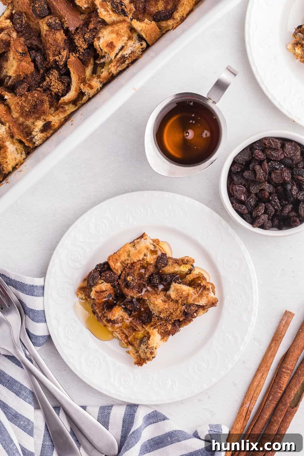 A slice of Cinnamon Raisin Breakfast Casserole elegantly plated, highlighting its golden-brown top and rich texture.